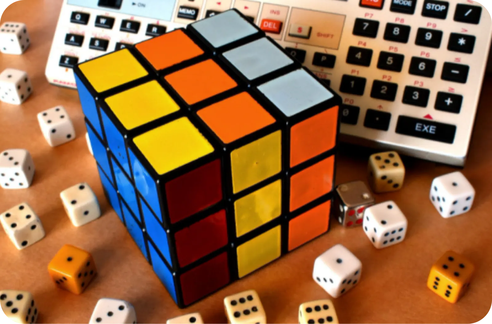 A Rubik's cube surrounded by dice and a calculator